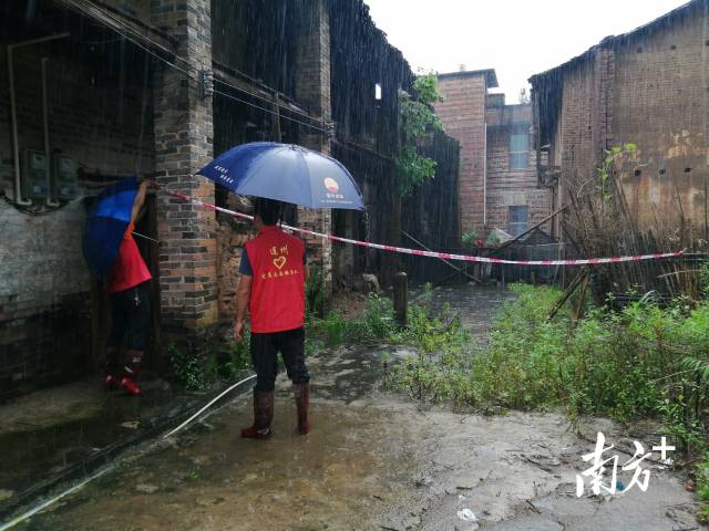 黨群志愿者冒雨拉起警戒線。