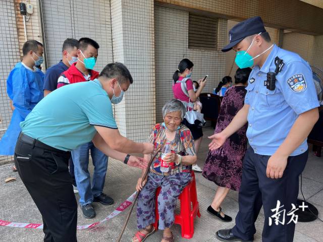 連州市委常委、副市長(zhǎng)、九陂鎮(zhèn)黨委書記綦鴻偉在核酸檢測(cè)現(xiàn)場(chǎng)協(xié)助老人參加核酸檢測(cè)，為老人做好防暑措施。